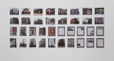 A group 36 photographs of exteriors of banks, hung on the wall in 4 rows