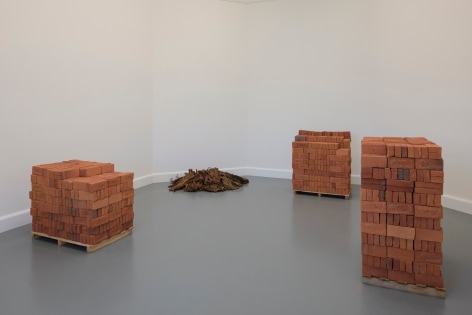 Rossella Biscotti, Clara, 2016, Installation with custom made bricks, tobacco, pallets and wall text in vinyl