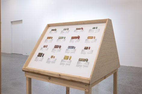 Michael Rakowitz, The invisible enemy should not exist (cylinder seals), 2022, Arabic newspaper and food packaging cardboard sculptures, museum labels