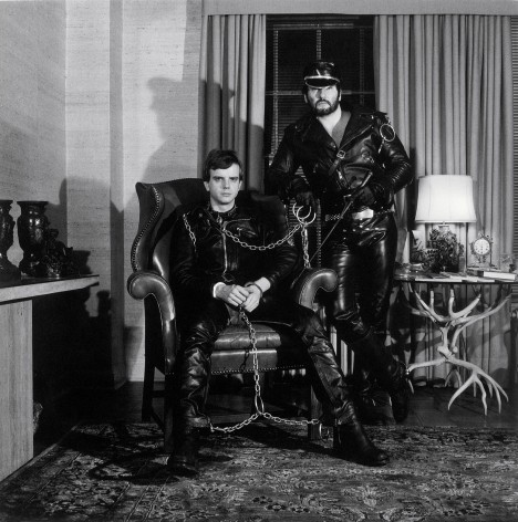 Portrait of two men in full leather outfits, facing camera head on.