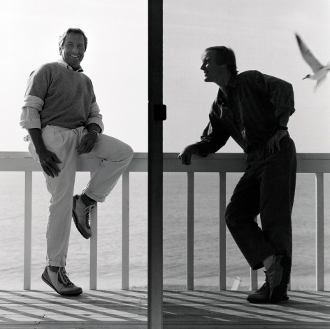 Robert Rauschenberg and another man standing on a balcony above water.