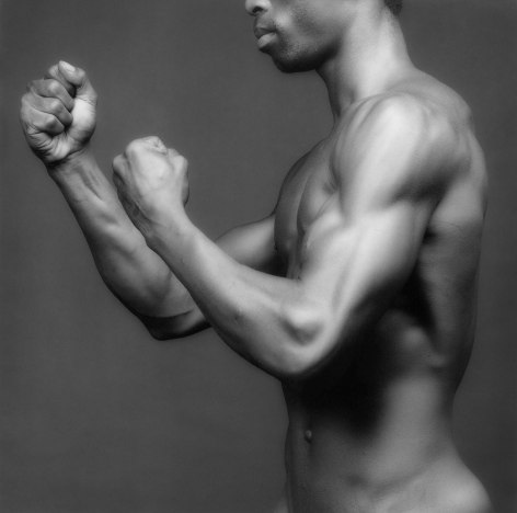 Dennis Speight in profile, holding up both hands in fists.