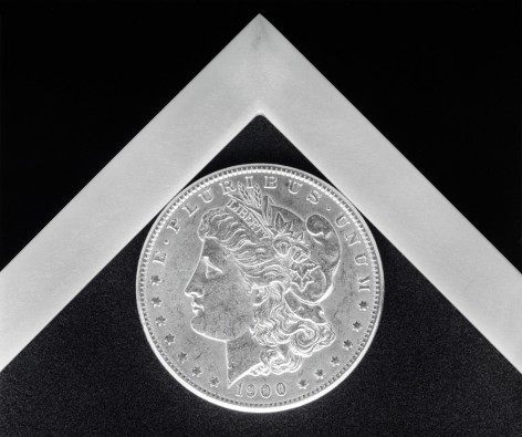 Coin nestled into the corner of a white graphic angle against a black background.