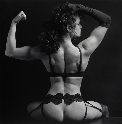 Lisa Lyon with back toward camera, wearing lingerie.