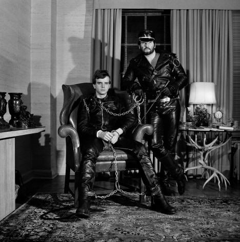 Portrait of two men in full leather outfits, facing camera head on.