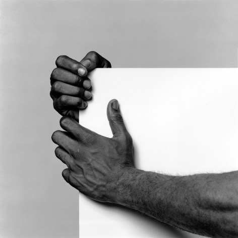 Lowell Smith's hands holding white square.