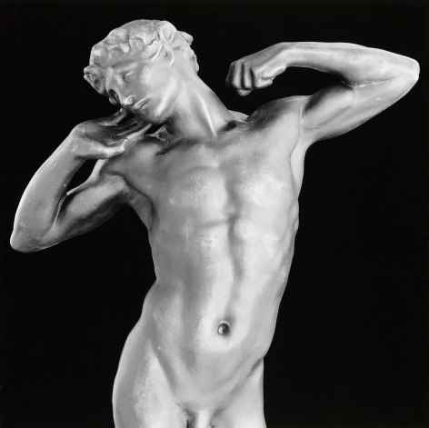 Marble statue of a young man stretching from the hips up.