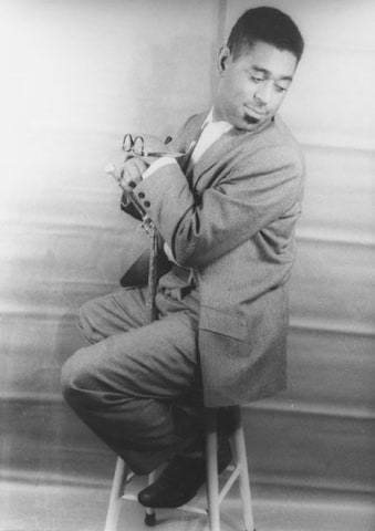 31. Carl Van Vechten, John Birks &quot;Dizzy&quot; Gillespie, 1955. Full-body seated portrait with subject glancing to the lower right of the frame with body facing the right, arms crossed in front of his chest.