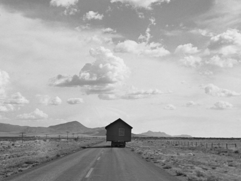 A house carried on a tractor trailer on an empty highway