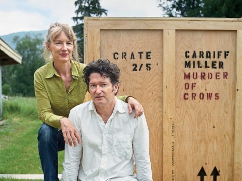 a man and a woman in front of a wooden crate