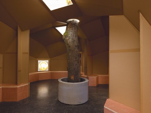Wood vertical sculpture installed in cardboard room