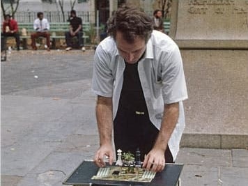 man looking at chessboard on table