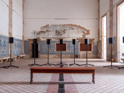 Sound installation of multiple speakers and bench in an old church