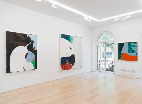 installation view of multiple paintings in a white room