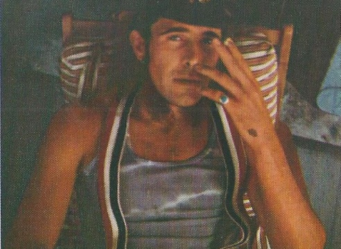 Man Smoking a cigarette in suspenders 
