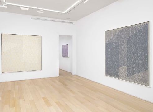 two abstract paintings in a white room