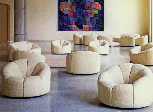 Cream boucle upholstered chairs in a reflection of a room with multiple of the same chair