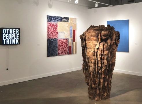 Art fair booth featuring sculpture and paintings