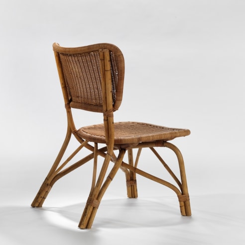 photograph of a rattan chair in a blank room 