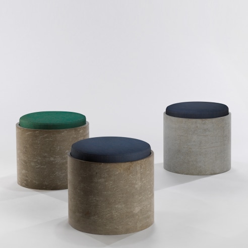 Set of three low concrete stools with cushions