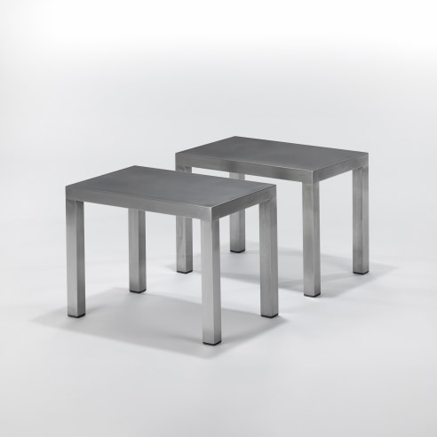 pair of steel tables in a blank room