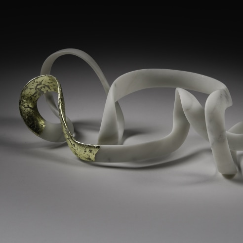 a sculpture by Elizabeth Turk of a thin looping bands of marble, a corner of which is covered in gold leaf