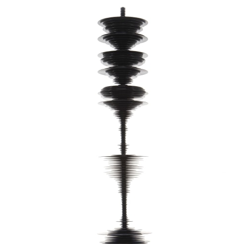 a sculpture by Elizabeth Turk of black aluminum discs stacked and arranged to simultaneously resemble a Modernist abstraction and a sound wave
