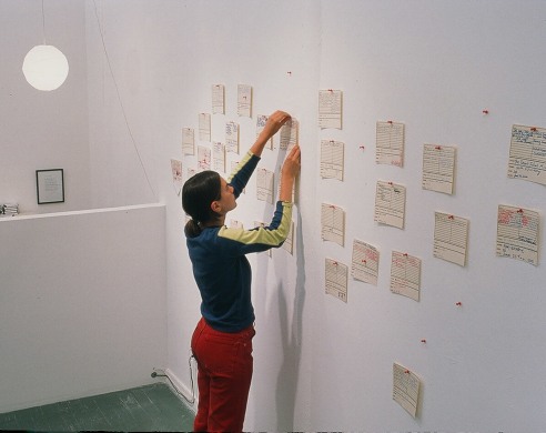 Photo of person pinning homemade mixtape listing to gallery wall