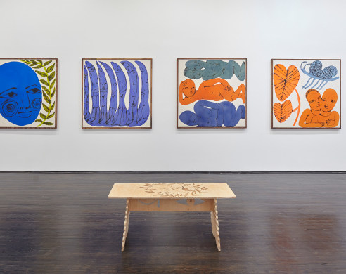 Installation view showing four paintings and wooden bench with engravings 