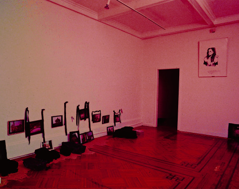 Installation view of red lit gallery