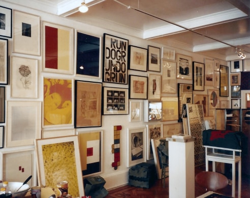 Installation view of varied artworks from past exhibitions on gallery wall