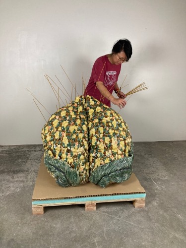 Cathy Lu placing incense on her sculpture,&amp;nbsp;Untitled (Tall Peach Incense Holder), 2021.