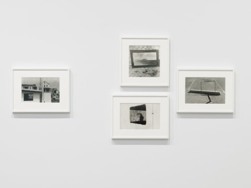 4 black and white photographs hung on a gallery wall
