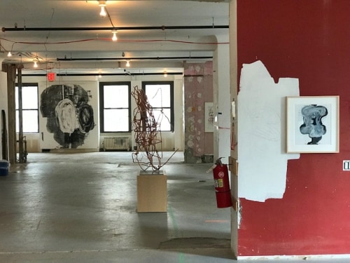 Art installation in raw office space with red and pink walls