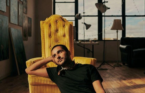 Salman Toor on a yellow chair in his studio