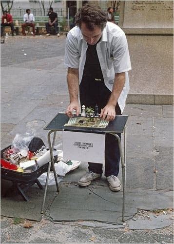 man looking at chessboard on table