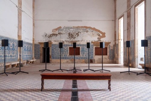Sound installation of multiple speakers and bench in an old church