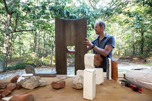 Mark Webber works on a wood sculpture outside his studio Credit: Francine Fleischer