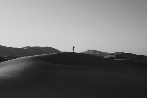 image of a desert with a man standing in the very center