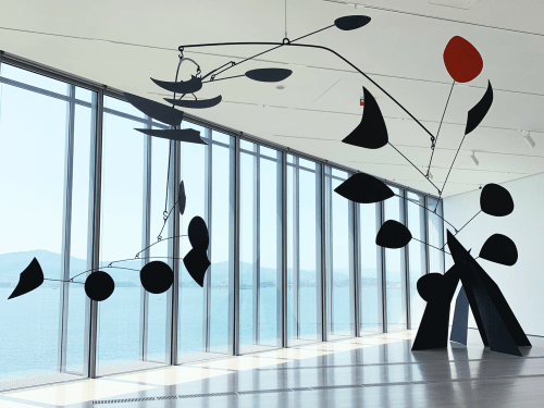 This image depict Alexander Calder and his installation crew about to suspend the black mobile, Untitled, 1954.