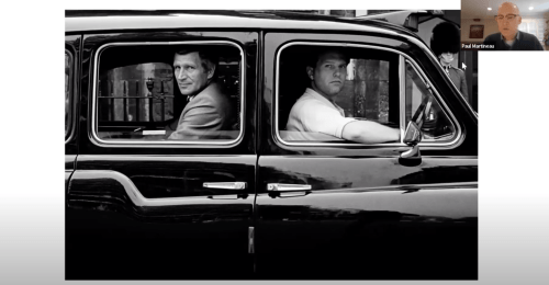 A screenshot of the Rodney Smith photograph John Hinch in Cab, London, England, 1987 which shows two men looking out a cab window in a black and white photograph. The screenshot includes the tiny thumbnail image of the speaker of the talk, Paul Martineau