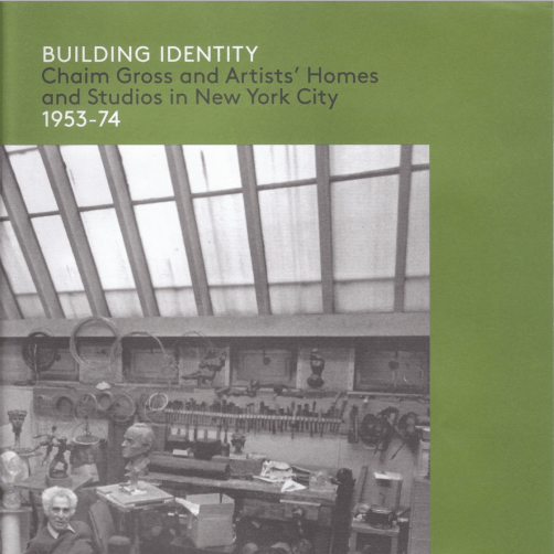 Exhibition catalogue cover, bearing a black and white photo of Chaim Gross sitting in his studio surrounded by his art and his tools, placed on top of a green background. The top of the cover is the title of the catalogue, "BUILDING IDENTITY" in white, followed by "Chaim Gross and Artists' Homes and Studios in New York City" in grey, and "1953-74" in white.