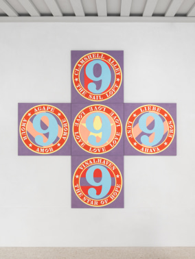 Love Cross, a cruciform painting with a lilac ground made up of five panels, each containing a circle with a blue number nine inside, and text wrapping around the edges of the circle.