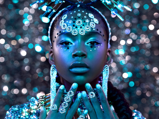 A young black girl is photographed in color wearing sparkling jewels and a tiara.