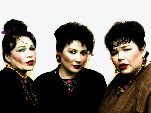 Three Native American women wear makeup and bouffant hairdos while they look at the camera.