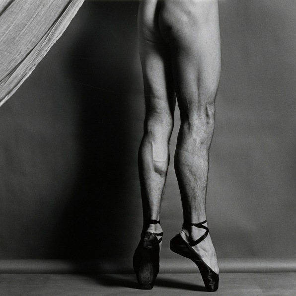 Dancer from the waist down, naked  except for pointe shoes, facing away from camera.