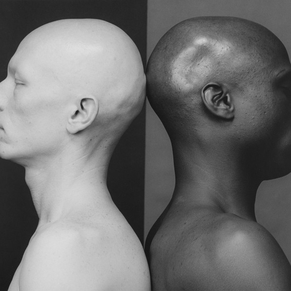 Two men in profile, facing apart with backs touching. 