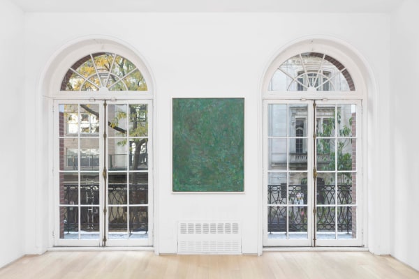 a green painting between windows