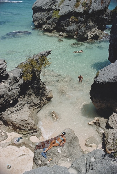 Slim Aarons, On The Beach In Bermuda, 1967: Sunbathing and swimming at a beach in Bermuda