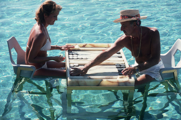 Slim Aarons, Keep your Cool 1978: Carmen Alvarez enjoying a game of backgammon  with Frank Brandstetter in a swimming pool in Acapulco, Mexico